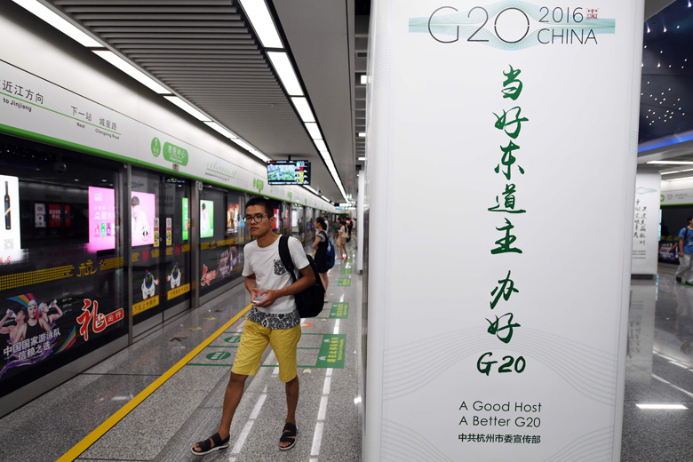 Ein Fahrgast vor einem G20-Poster in einer U-Bahn-Station.jpg